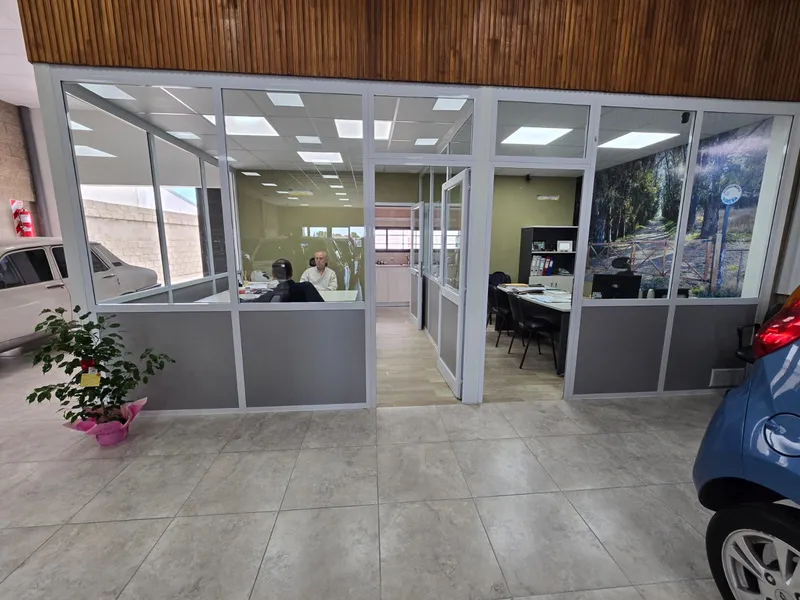 Oficinas internas cerradas con paños fijos de PVC blanco en el salón