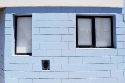 Detalle de dos ventanas corredizas de aluminio en la fachada del complejo