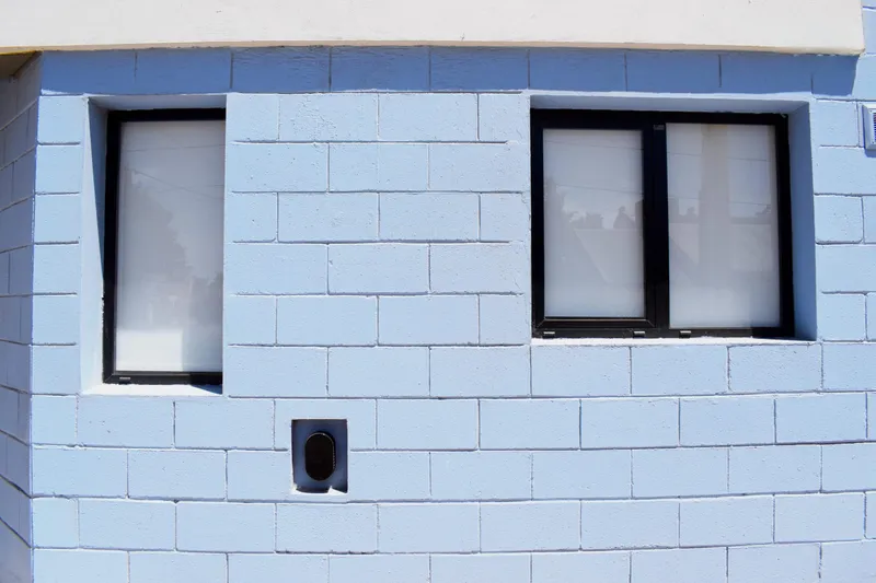 Detalle de dos ventanas corredizas de aluminio en la fachada del complejo