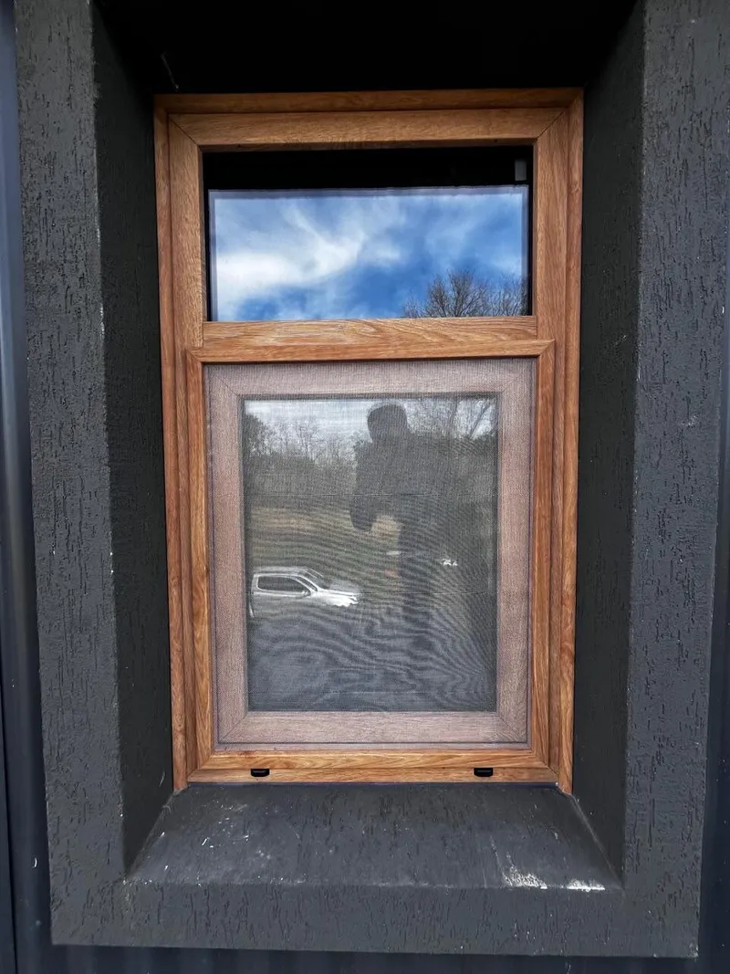 Ventana chica de PVC roble dorado con mosquitero y banderola fija en el baño