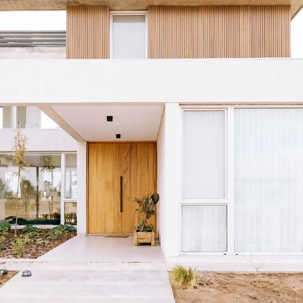 Frente de casa en General Pico con ventana de aluminio anodizado natural junto al acceso
