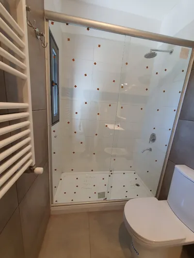Mampara de vidrio templado en el baño de un departamento del complejo