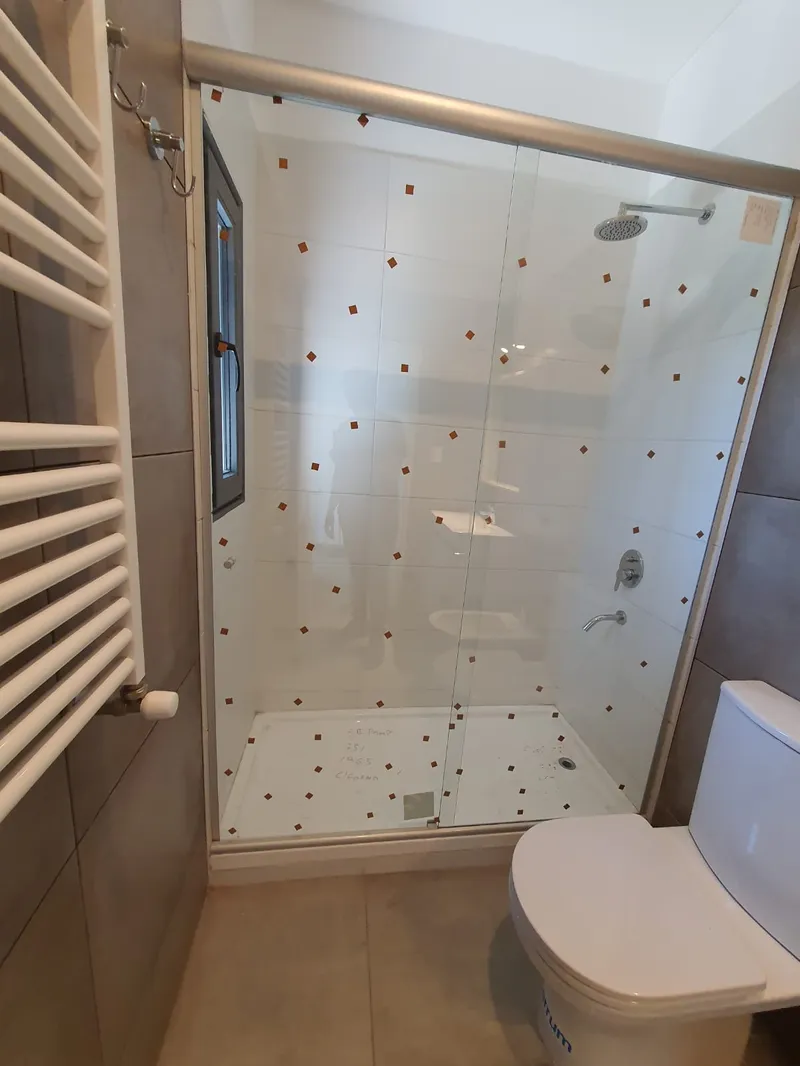 Mampara de vidrio templado en el baño de un departamento del complejo