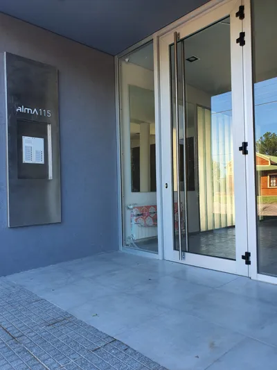 Acceso al complejo Alma 115 con puerta y paños fijos de aluminio