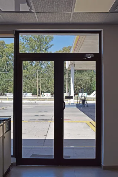 Puerta de doble hoja de aluminio negro en el acceso de la estación de servicio