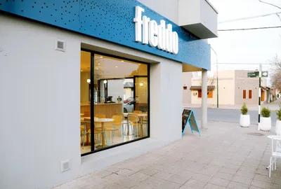 Frente de la heladería Freddo sobre la esquina con carpintería de aluminio negro