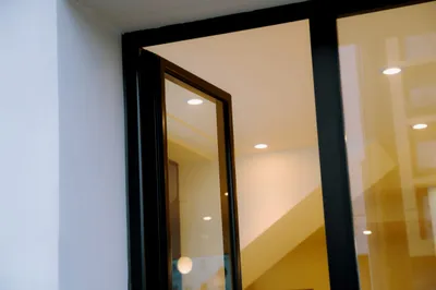 Detalle del encuentro de la vidriera de aluminio negro con la pared