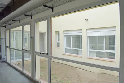 Corredor de la UTI pediátrica con paños fijos de PVC blanco al patio interno