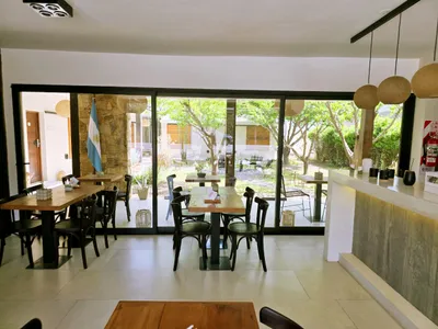 Comedor del hotel con ventanal corredizo de aluminio negro abierto al patio