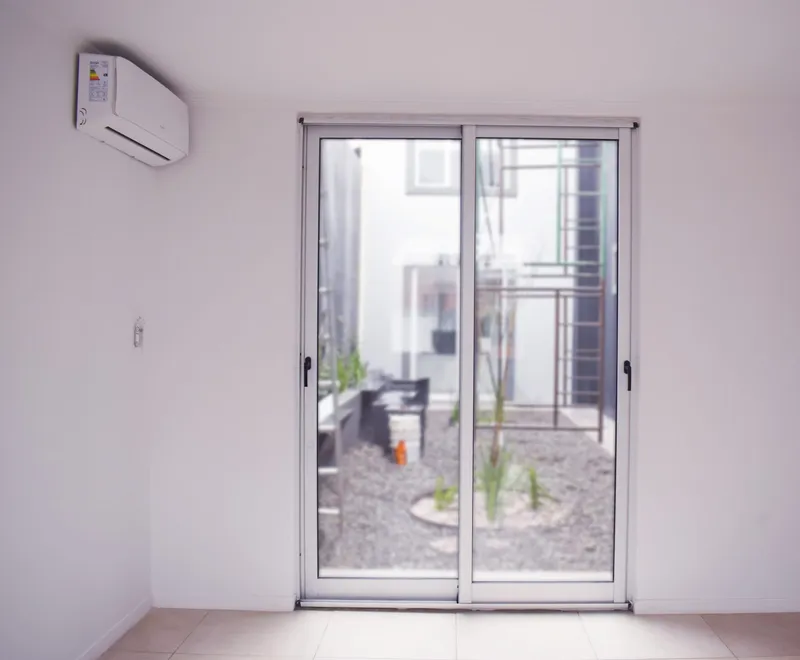 Puerta ventana corrediza de aluminio anodizado con salida al patio