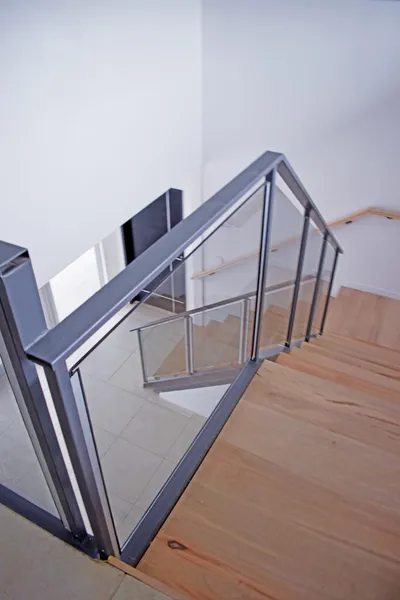 Baranda de cristal con perfilería de aluminio en la escalera interna