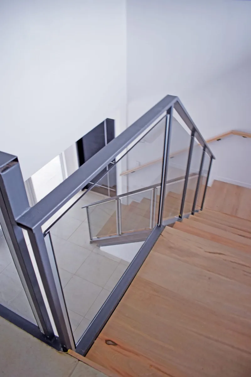 Baranda de cristal con perfilería de aluminio en la escalera interna