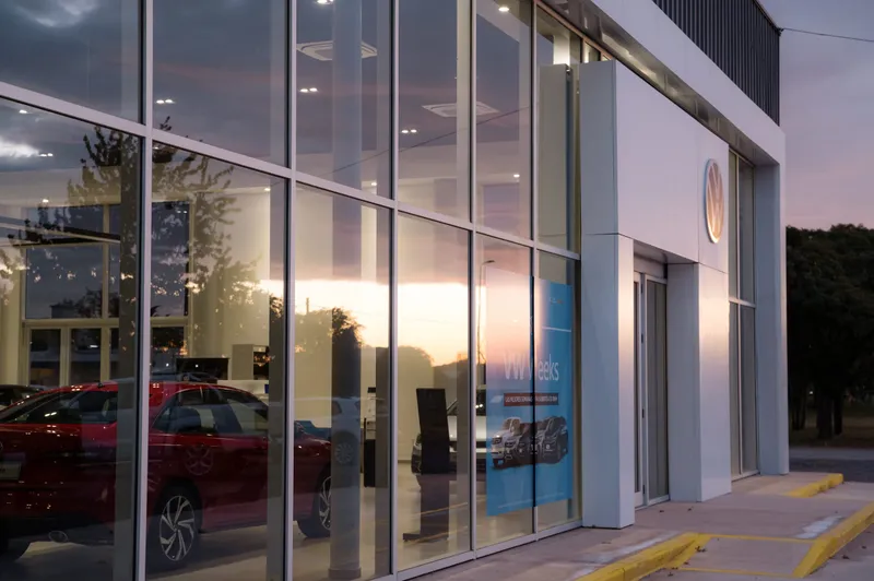 Frente vidriado del salón de ventas con los autos en exhibición