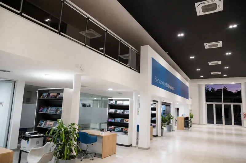 Salón de exhibición del concesionario con entrepiso vidriado y paños de aluminio