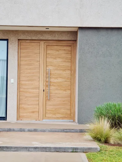 Puerta de entrada de PVC de dos hojas color Turner con manijones de acero