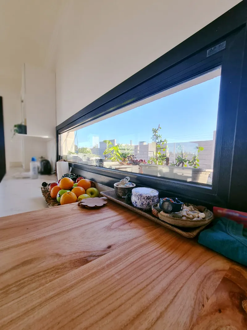 Ventana apaisada de PVC negro sobre la mesada de la cocina en General Pico