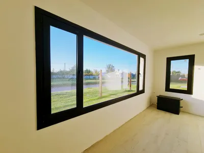 Ventana corrediza apaisada de PVC negro en el dormitorio