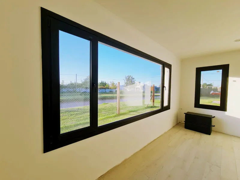 Ventana corrediza apaisada de PVC negro en el dormitorio