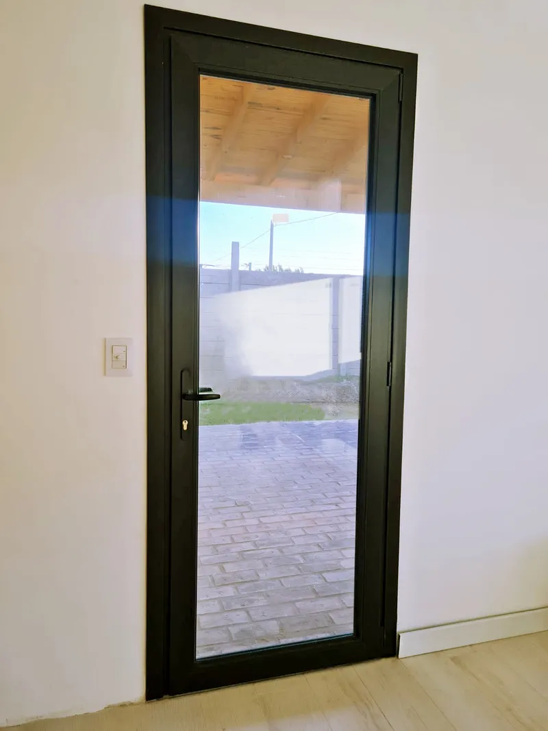 Puerta de abrir de PVC negro vidriada con salida al patio