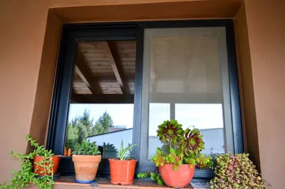 Ventana corrediza de aluminio negro con cortina de enrollar