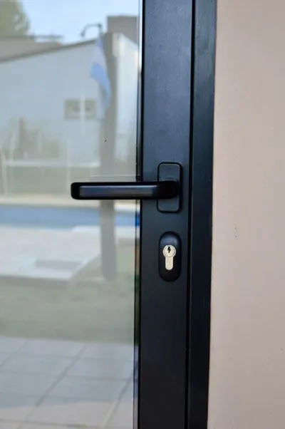 Detalle de la manija y la cerradura de la puerta de aluminio negro