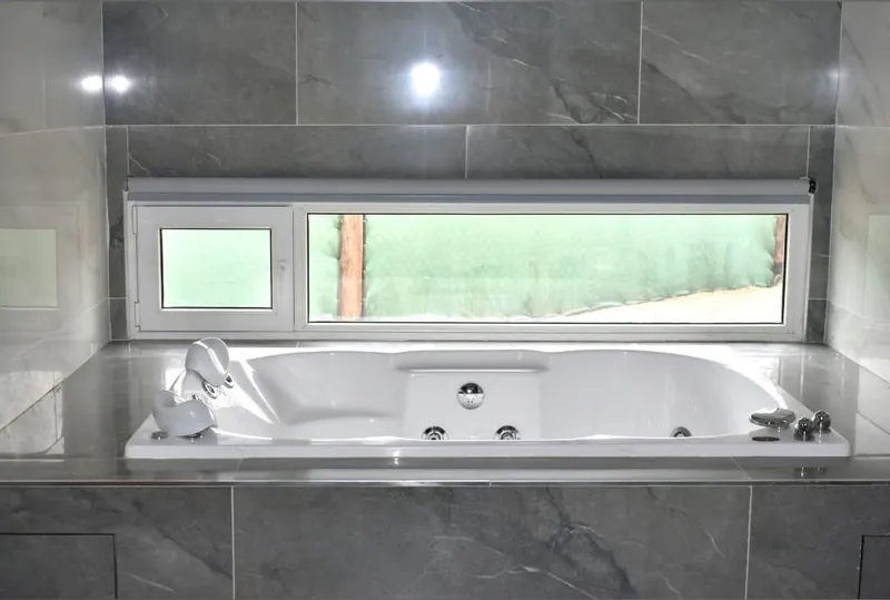 Ventana apaisada de PVC blanco con paño fijo y hoja de abrir sobre la bañera