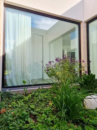 Paños fijos de aluminio negro de piso a techo alrededor del patio