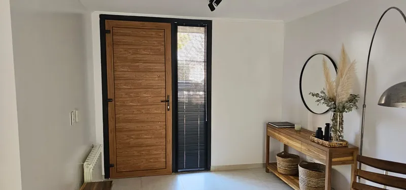 Hall de entrada con puerta de PVC Turner y paño fijo lateral negro