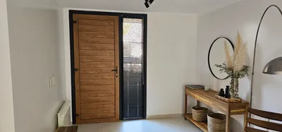 Hall de entrada con puerta de PVC Turner y paño fijo lateral negro