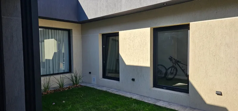 Frente al patio con ventanas de PVC negro de gran superficie