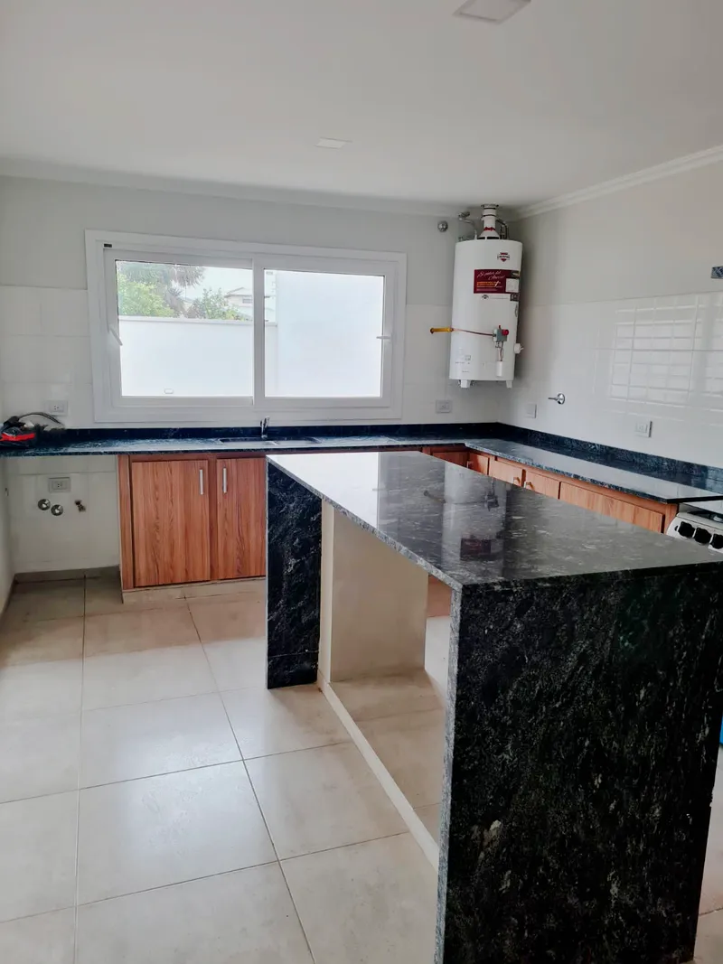 Cocina con ventana corrediza de PVC blanco sobre la mesada
