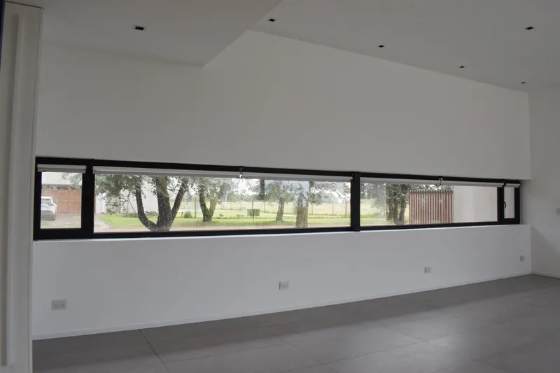 Ventana horizontal apaisada de PVC negro en el living