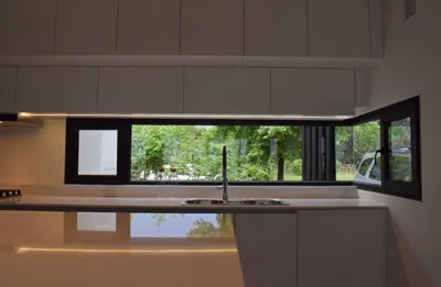 Ventana esquinera de PVC negro sobre la mesada de la cocina