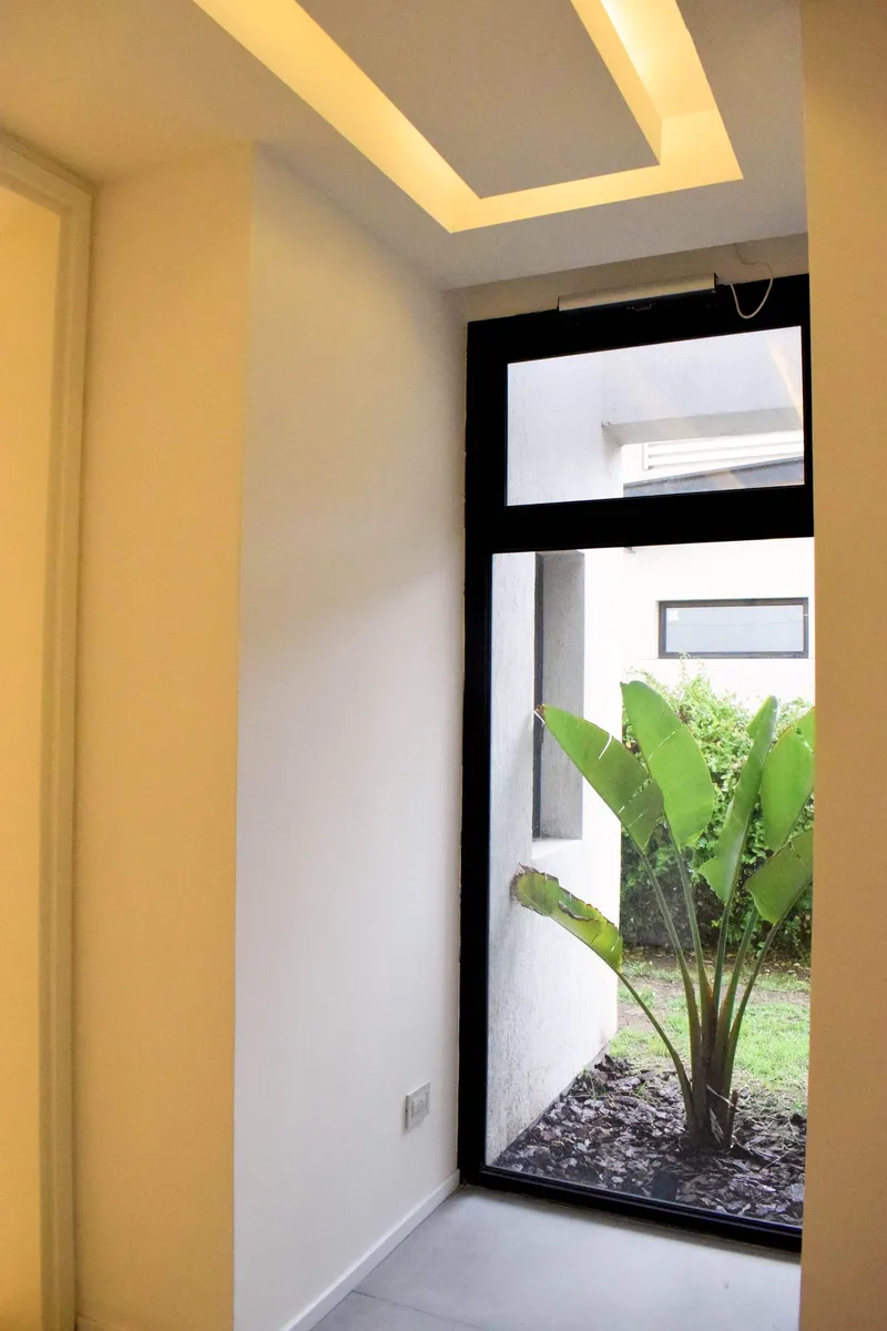 Paño fijo de PVC negro de piso a techo hacia el patio interno
