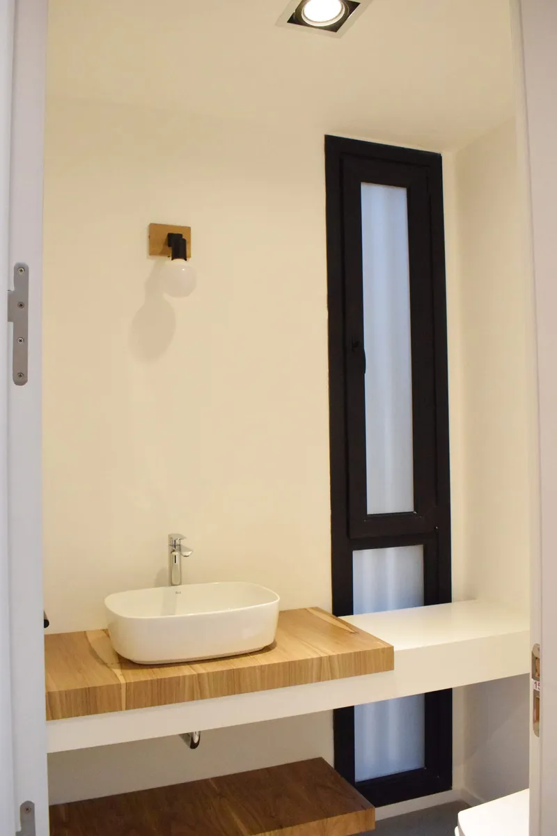 Baño con paño fijo vertical de PVC negro y vidrio esmerilado